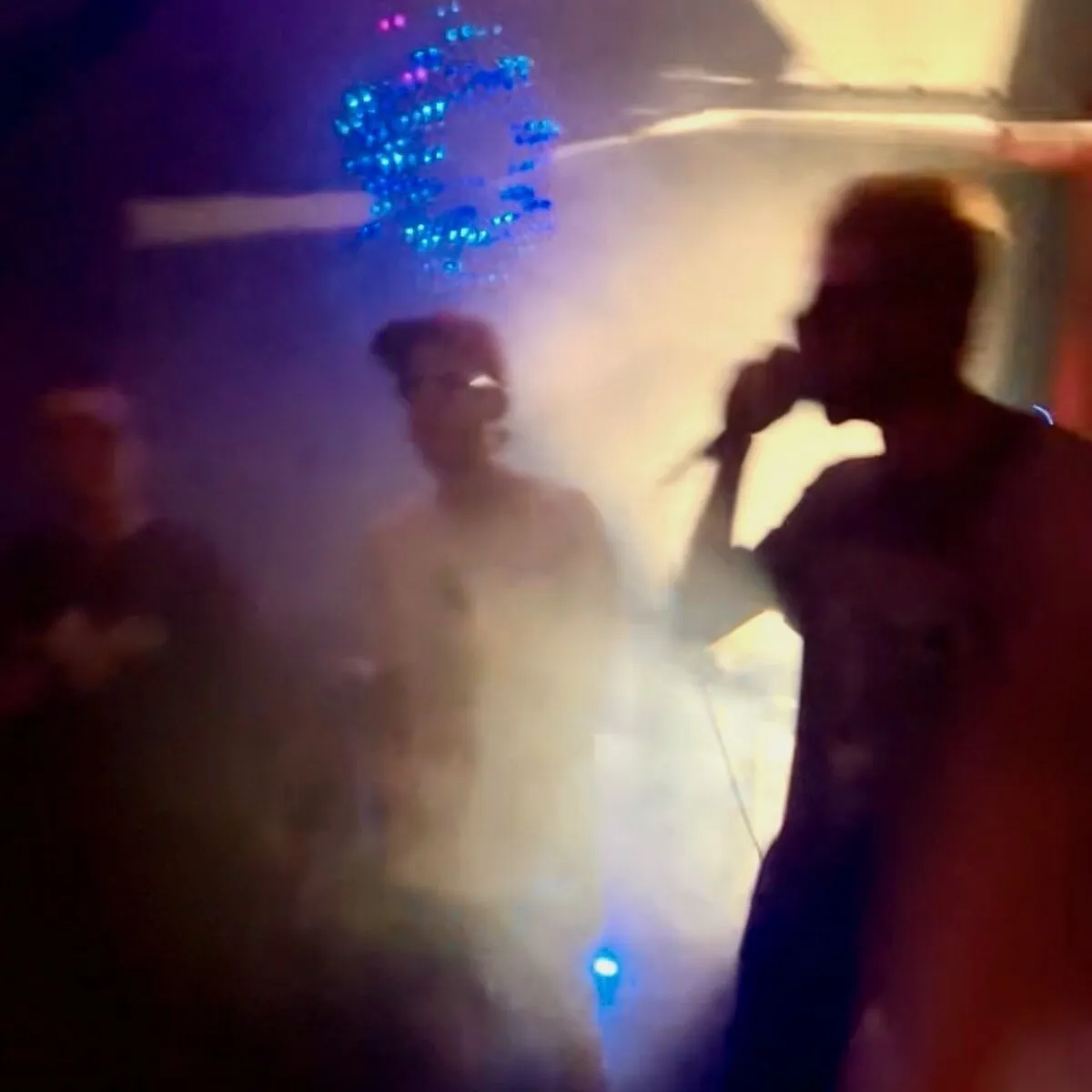 The British Experience: three performers silhouetted in blue and amber light